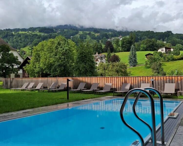 Outdoor-Pool mit Blick auf die grünen Berge in Schruns, Montafon