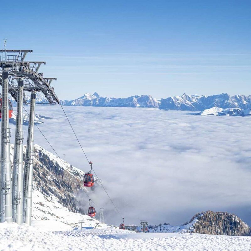 Sessellift am Kitzsteinhorn über einem Nebelmeer mit Blick auf die Hohen Tauern