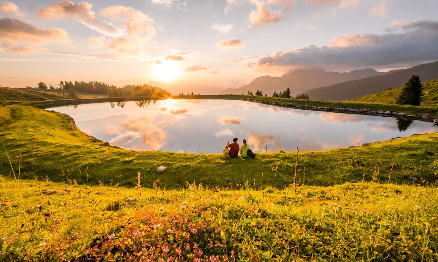 Wanderer auf einem Sommerwanderweg am Nassfeld mit weiter Aussicht auf die alpine Berglandschaft