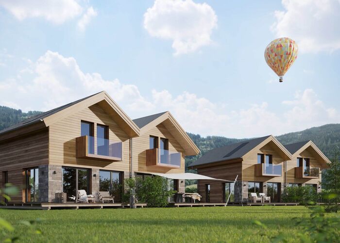 Moderne vakantiehuizen van Sonnenchalets Murau met terrassen, een tuin en uitzicht op de omliggende bergen.