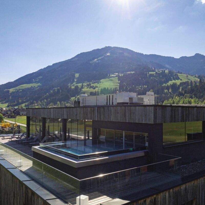 Hotel resort with outdoor pool in a summery mountain landscape