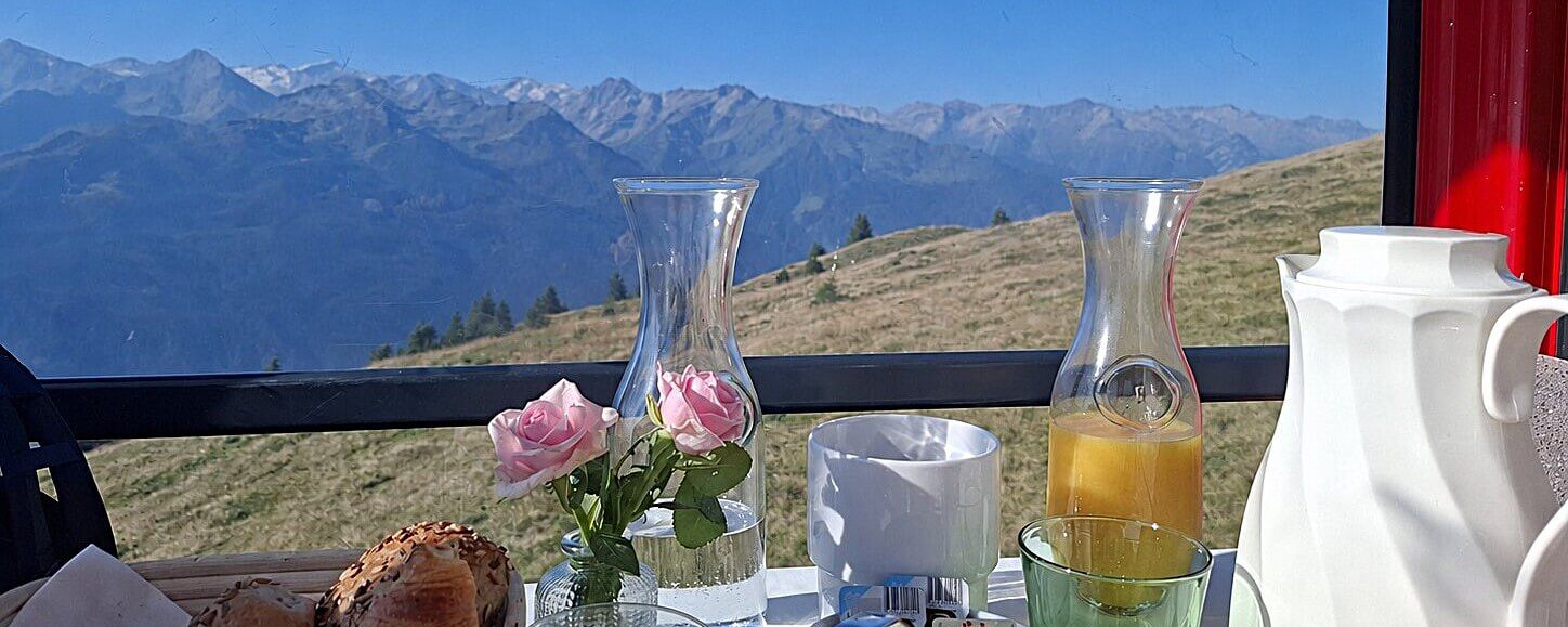 Ein Gondelfrühstück mit frischen Brötchen und Blick auf die majestätischen Berge in der Ferne.