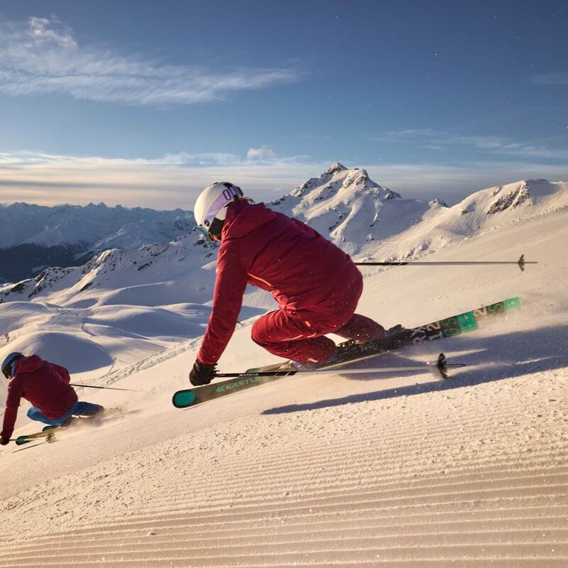 2 skiërs werken een lange afdaling af op de vers geprepareerde piste in het skigebied Silvretta-Montafon.