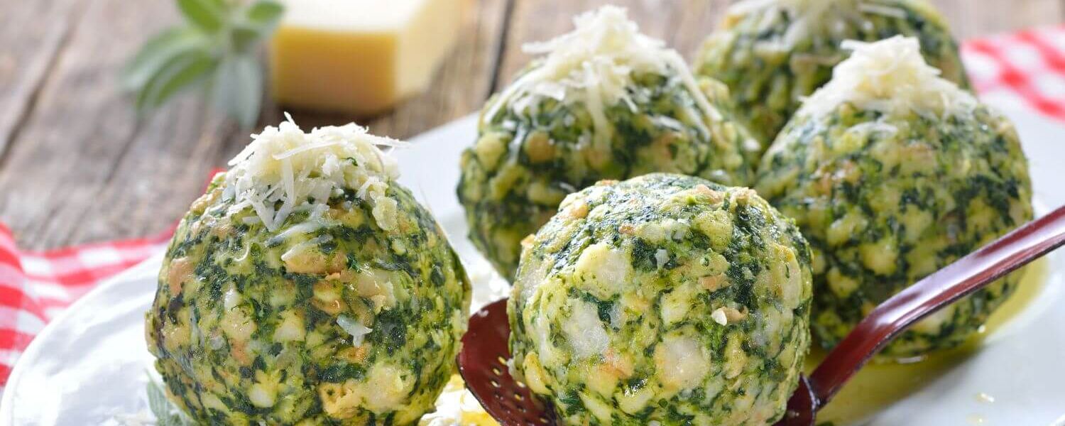 Grüne Spinatknödel auf einem Teller zeigen, wie einfach Meal Prep für die Ferienwohnung sein kann.