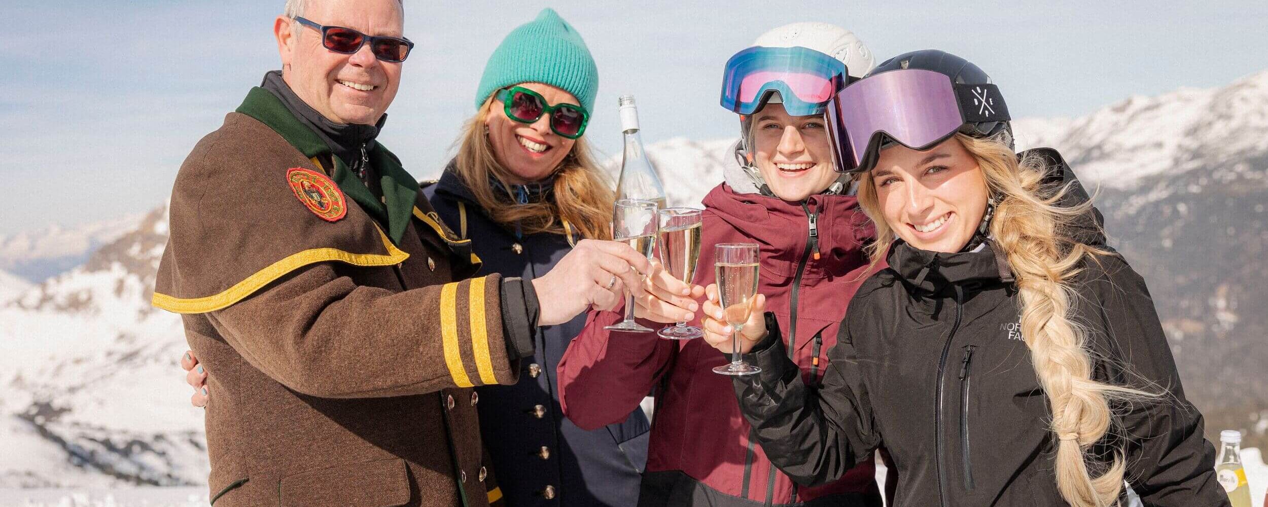 Gruppe lächelt in die Kamera mit Sekt am Gipfel, Winterüberraschung auf der Turrach