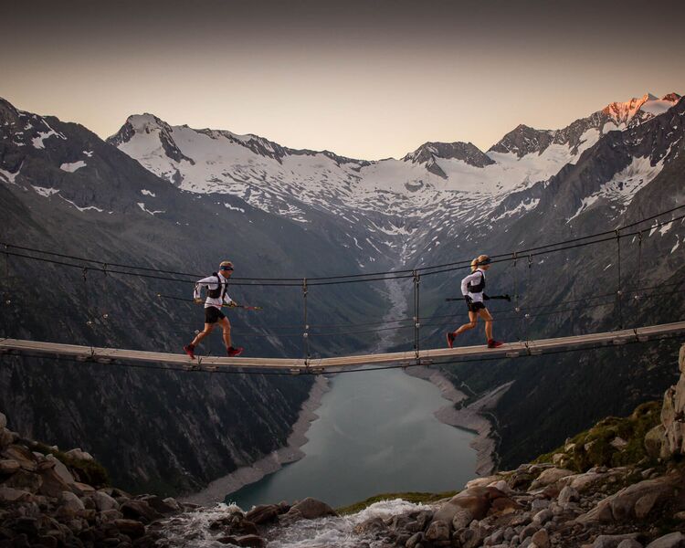 Hängebrücke über dem türkisfarbenen Schlegeisspeicher im Zillertal mit Bergpanorama — beliebter Wander- und Fotospot.