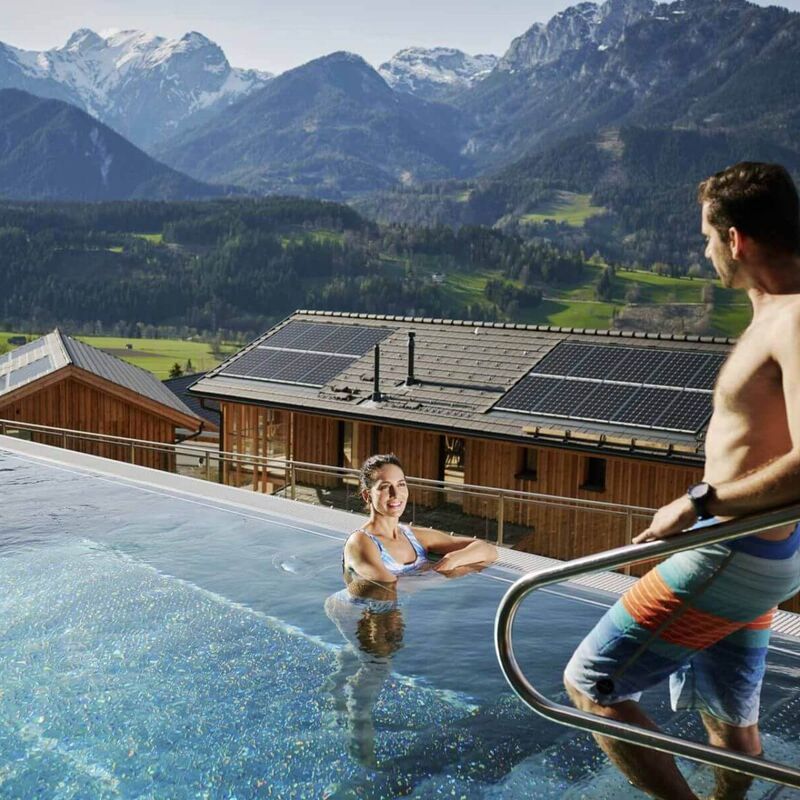 A couple in a pool in front of holiday homes