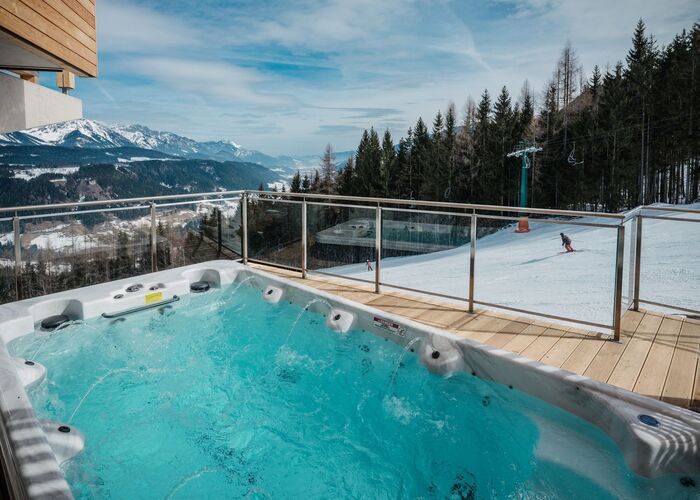 Gemütlicher Whirlpool auf der Terrasse eines Ferienhauses direkt an der Skipiste