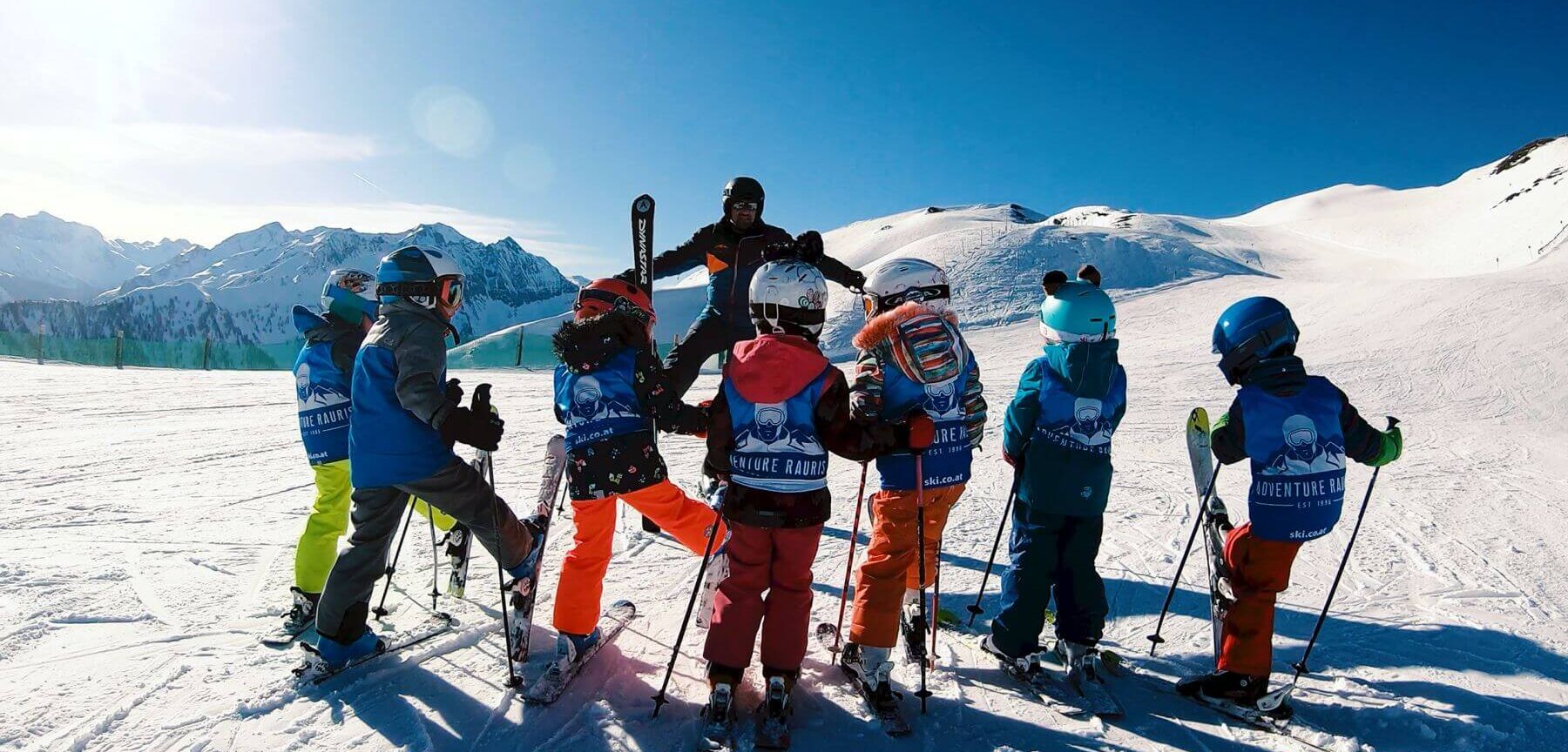 Skilehrer mit einer Kinderskigruppe auf der Piste