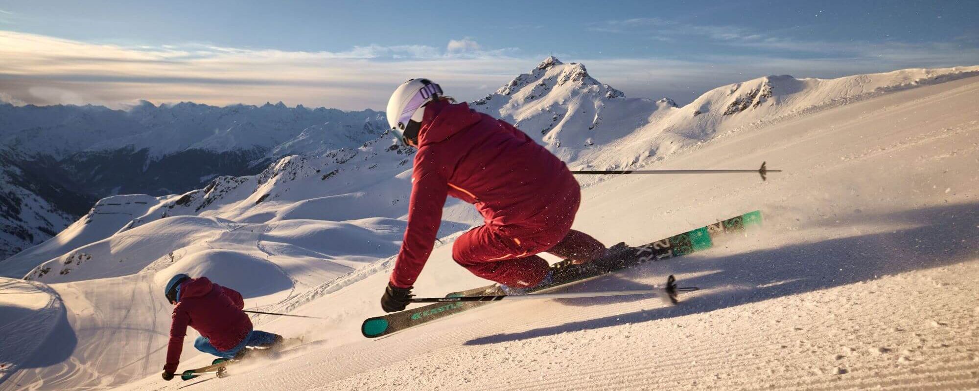 2 skiërs werken een lange afdaling af op de vers geprepareerde piste in het skigebied Silvretta Montafon.