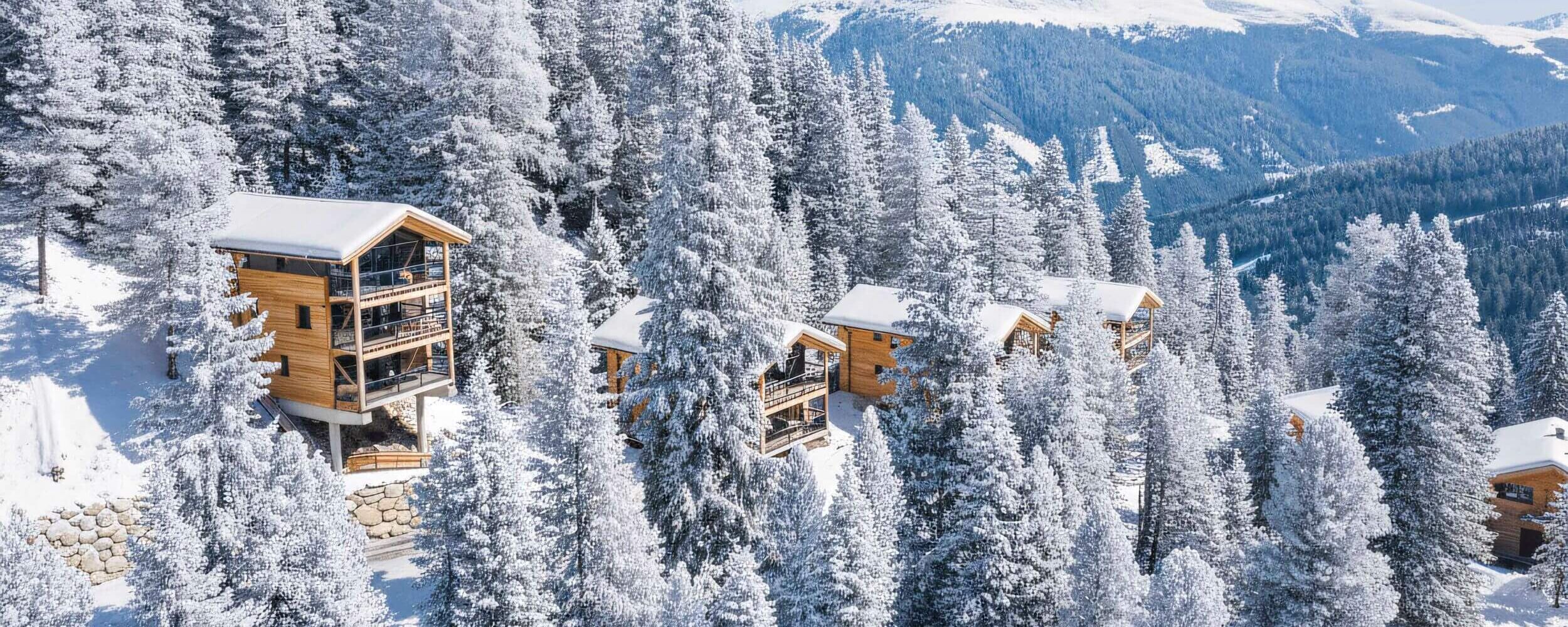 Chalets inmitten des tiefverschneiten Zirbenwaldes