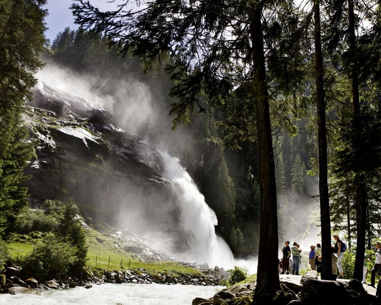 Gruppe von Ausflugsgästen bestaunt die mächtigen Krimmler Wasserfälle.