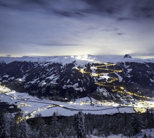 Night shot of the 14 km long, floodlit toboggan run in the Wildkogel Arena