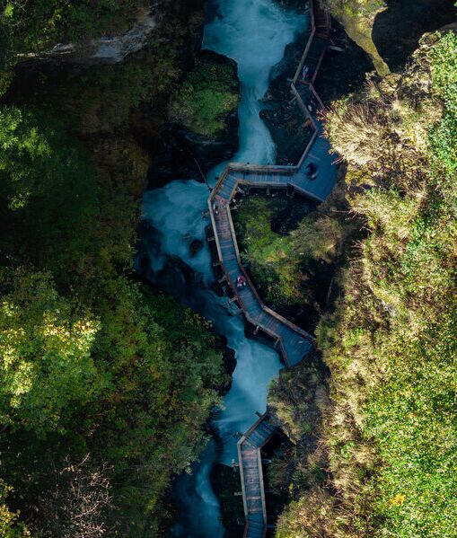 Blick von oben auf die Sigmund Thun Klamm mit tosendem Wasser und Holzsteigen.