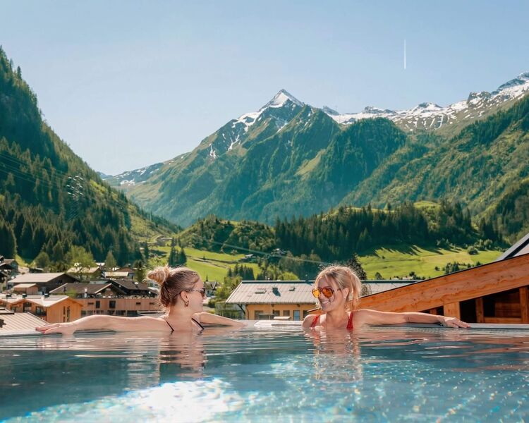 Zwei Frauen entspannen im Pool mit Blick auf die Berge und die malerische Landschaft.