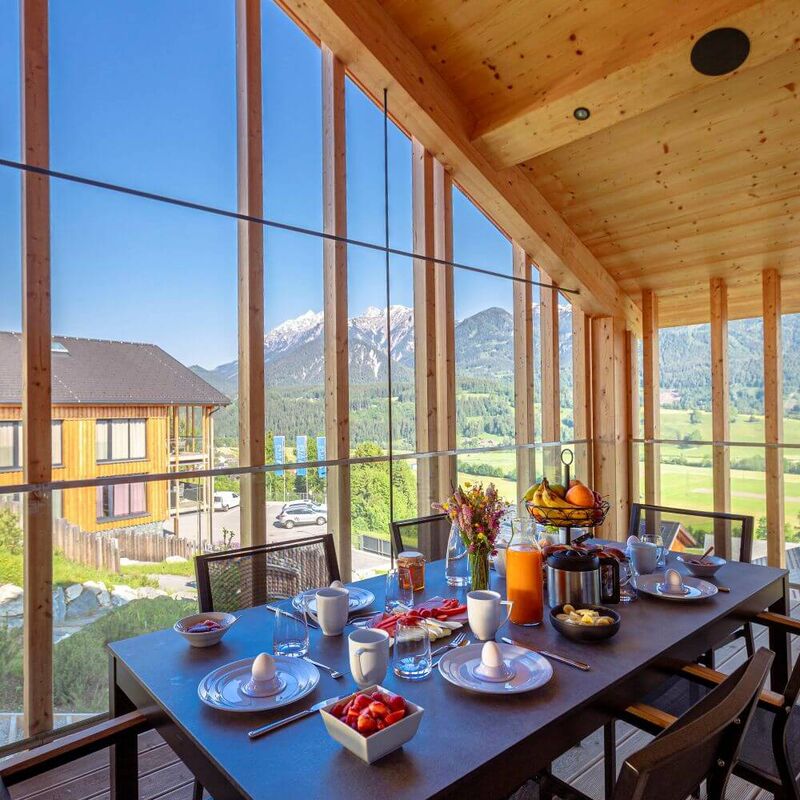 A table set in a holiday flat with a view of the Dachstein massif