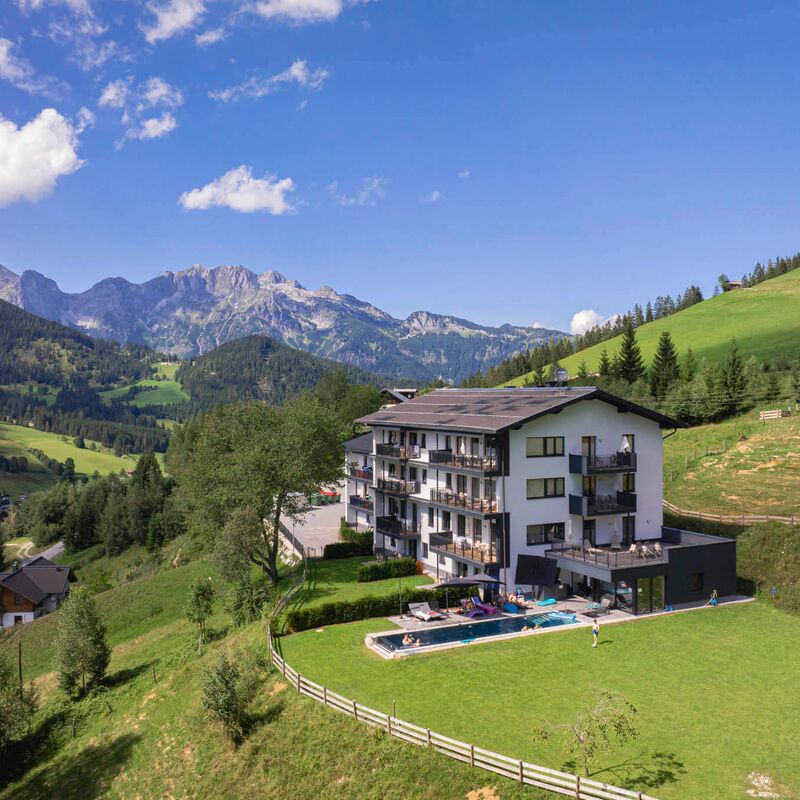 Apartment resort with outdoor pool surrounded by mountains