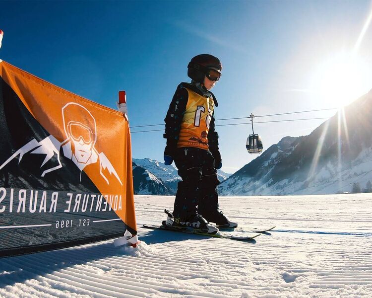 Child's first attempts on skis in the flat children's practice area
