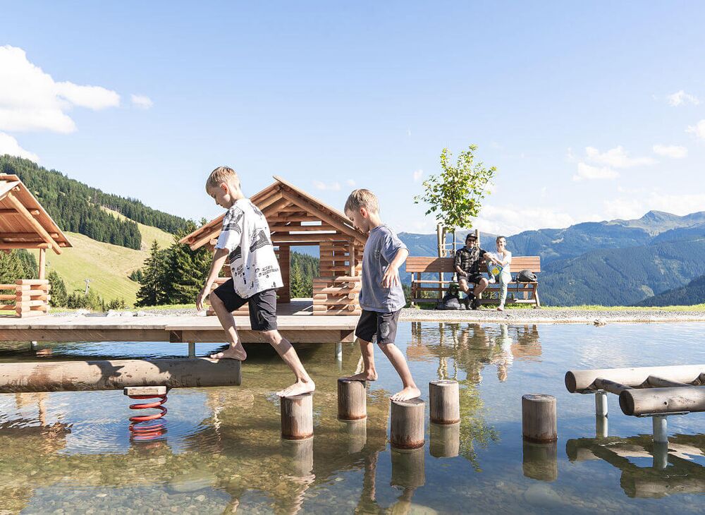 Kinder spielen im Wasserspielplatz in den Bergen