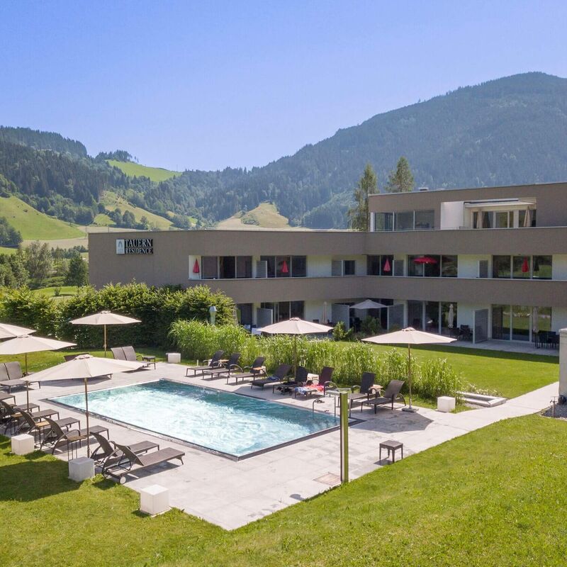 Entspannen am Pool der Tauernresidence Radstadt umgeben von Bergen und Wiesen