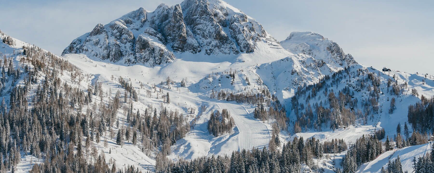 Winterwanderer mit Blick über das Nassfeld und die umliegende Berglandschaft