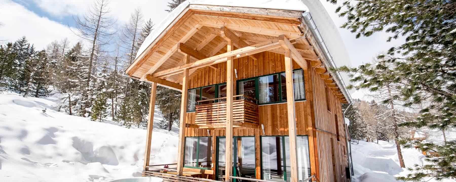 Ferienhaus in Schnee bedeckter Waldlandschaft und Hot Tub