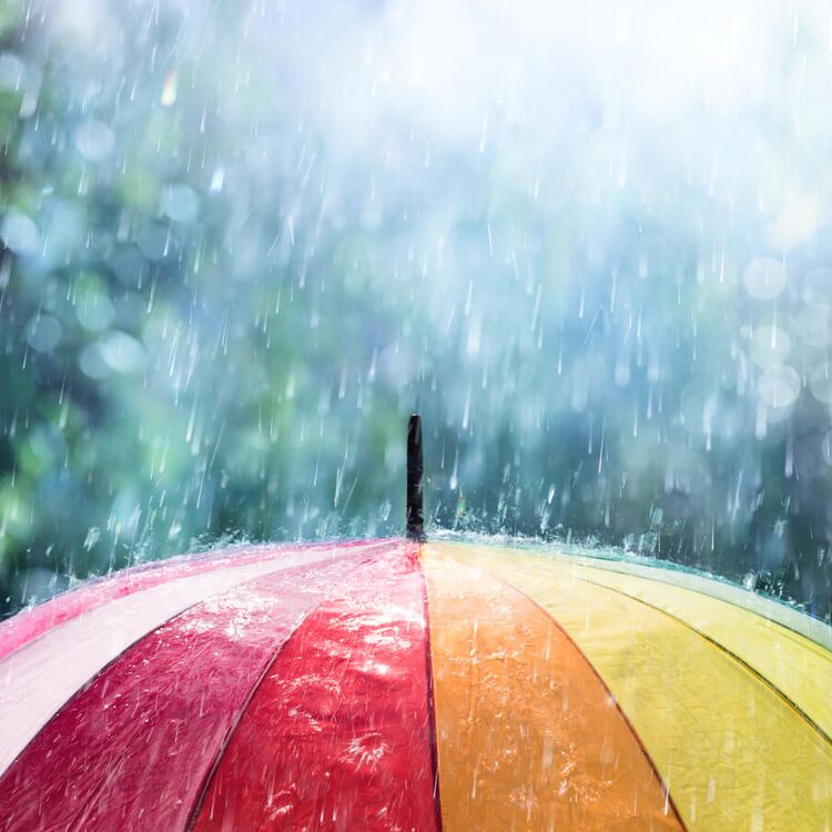 Bunter Regenschirm im strömenden Regen
