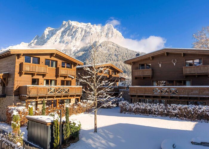 Buitenaanzicht van Bergresort Zugspitze Ehrwald in de winter, omringd door een besneeuwd landschap en de Tiroolse bergen.