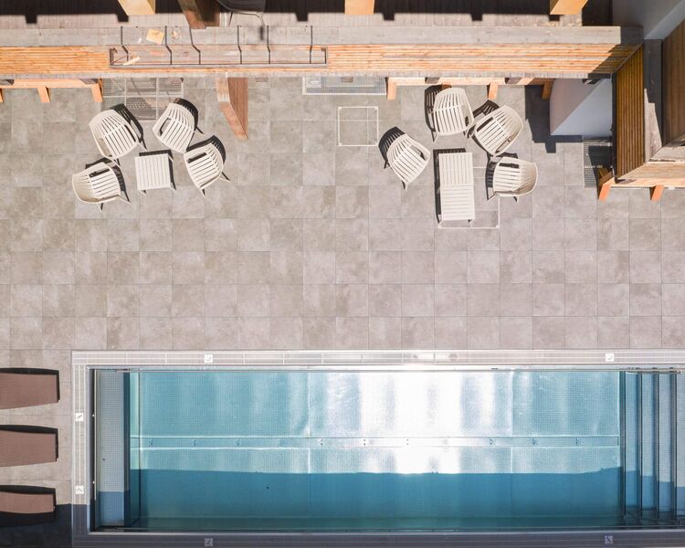 Exterior view of Saalbach Suites in Saalbach-Hinterglemm with pool and surrounding mountain scenery