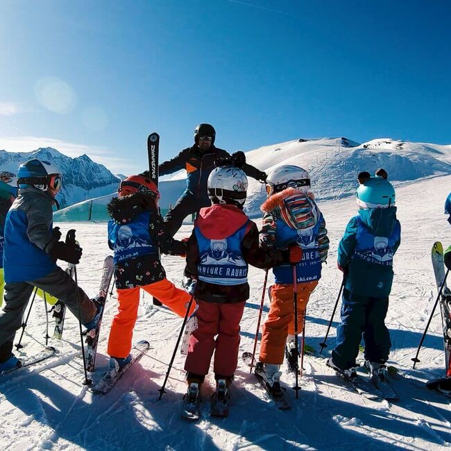 Skilehrer mit einer Kinderskigruppe auf der Piste