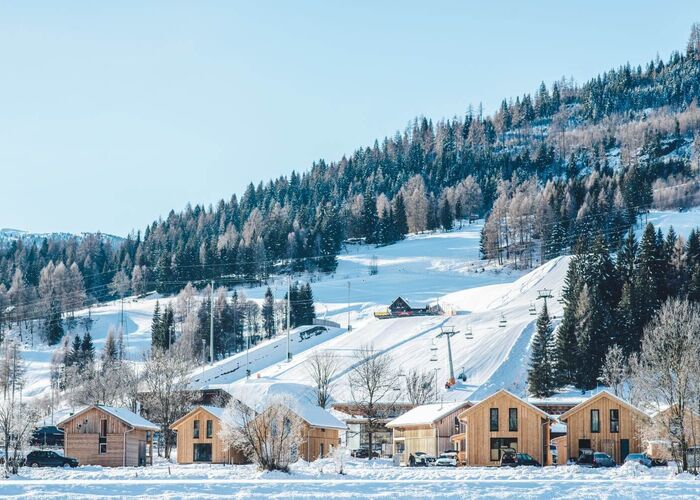 Kreischberg Chalets nestled in snowy mountains provide a cozy retreat near the ski slopes.