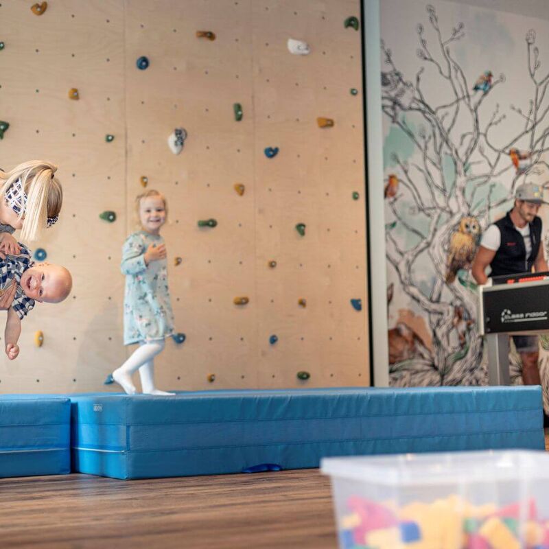Familie mit Kleinkindern im Kinderspielraum eines Aparthotels