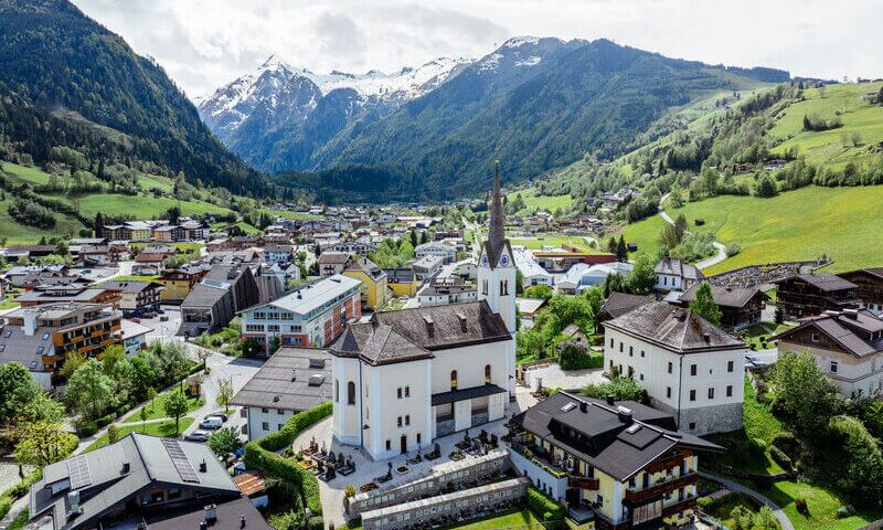 View from above of Kaprun’s village centre with its church, with the Kitzsteinhorn rising in the background.