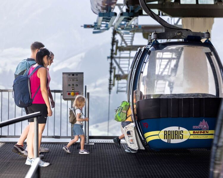 Familie im Wanderoutfit steigt in die Gondel ein.