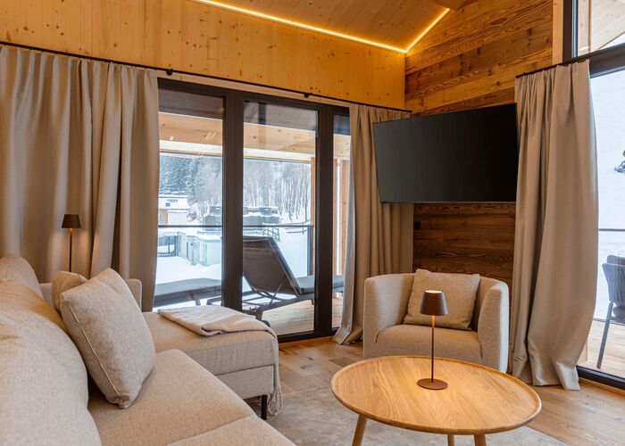 Moderner Wohnbereich der Saalbach Suites mit Sofa und alpinem Interieur