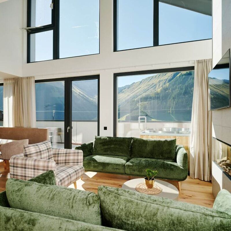 Modern living room with outdoor hot tub and mountain view at Bergresort Berwanger Hof