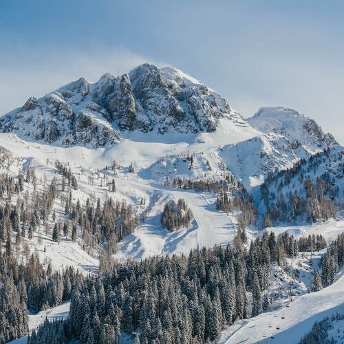 Winterwanderer mit Blick über das Nassfeld und die umliegende Berglandschaft