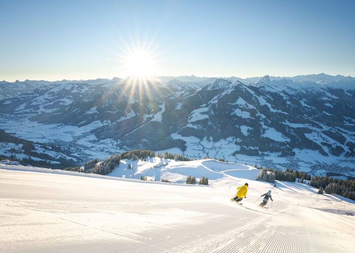 Zwei Skifahrer auf der frisch präparierten Piste mit Panoramablick