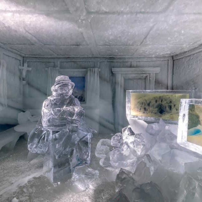 An icy room features a crystal statue and illuminated ice displays, capturing glacial beauty at Dachstein EisPalast.