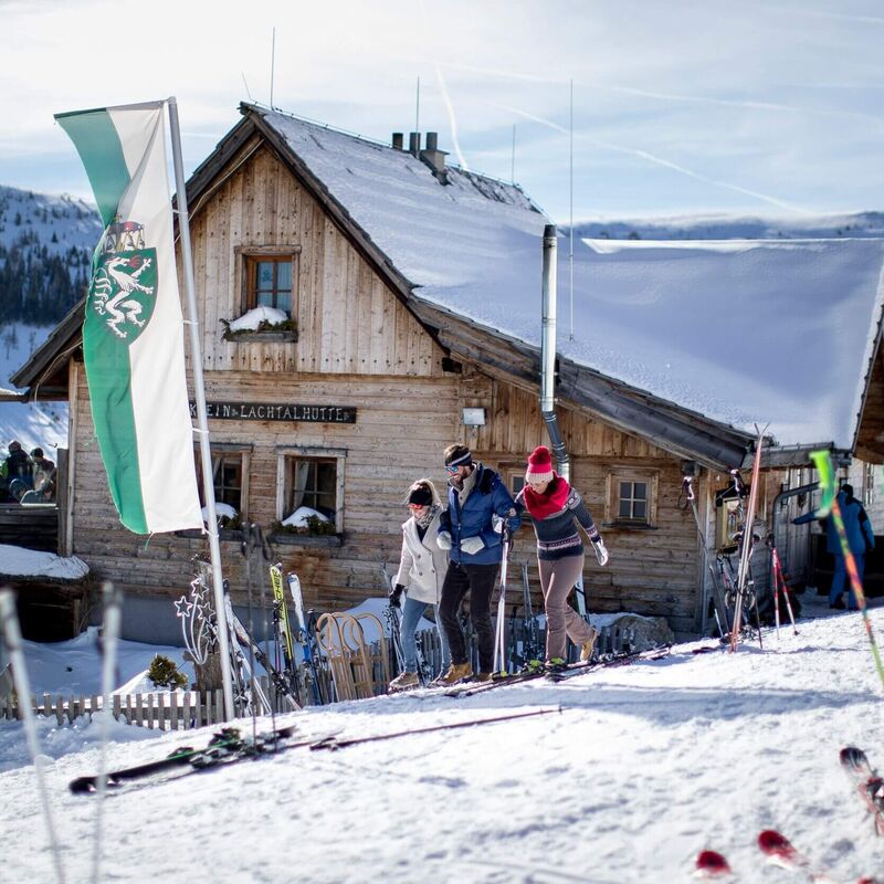 Skihütte im Skigebiet Lachtal mit Flagge der Steiermark und abgestellten Skiern