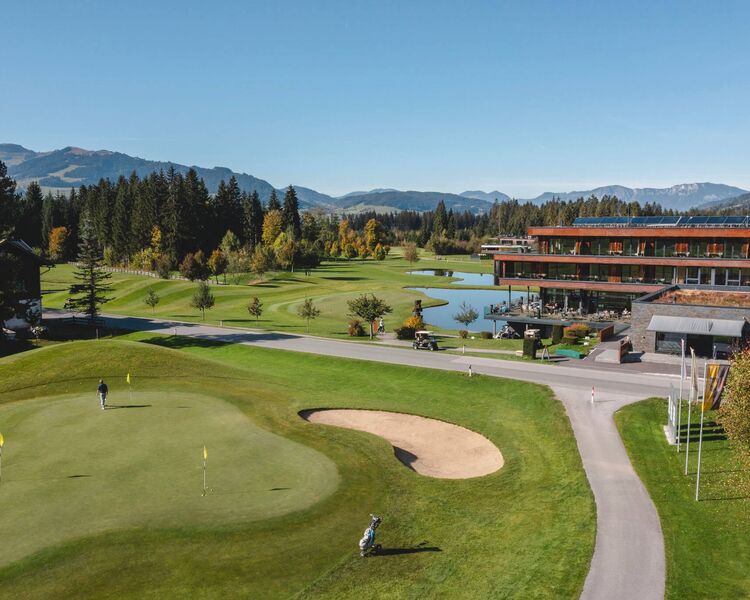 Grün mit Bunker auf dem Golfplatz, im Hintergrund das Bergresort Westendorf