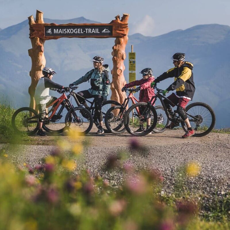 Familie mit 2 Kindern mit ihren Bikes am Start eines Bike-Trails.