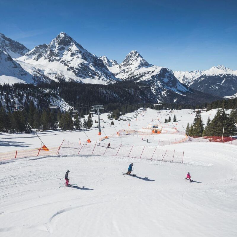 Eltern mit Kind beim Skifahren in einer Funslope