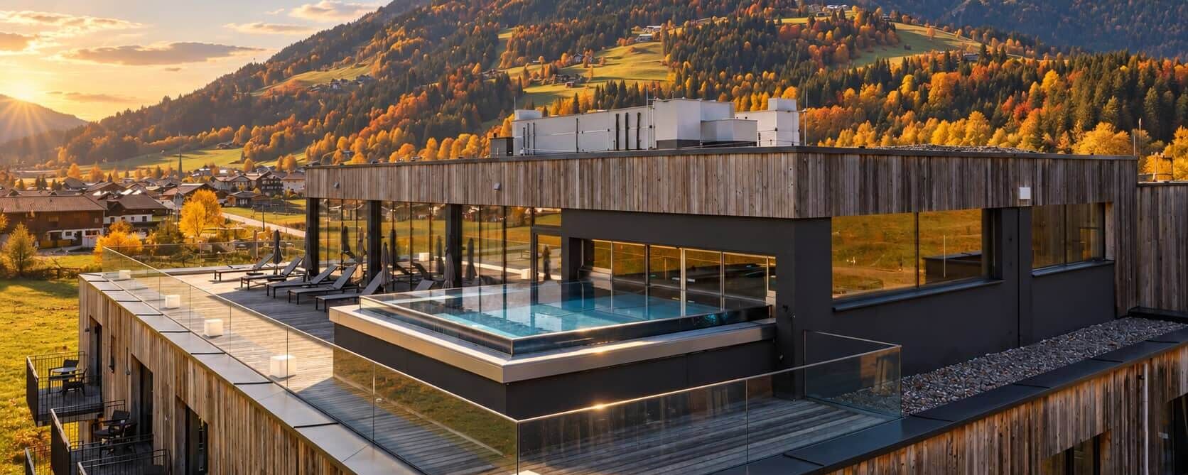 Außenansicht des Bergresort Westendorf mit Pool und herbstlicher Berglandschaft
