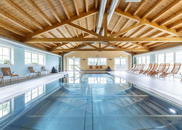 Bright indoor pool with sun loungers