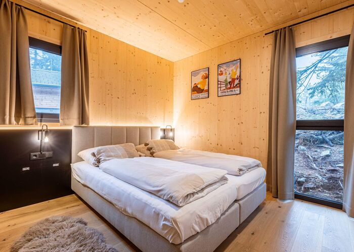 Schlafzimmer in einem Chalet auf der Turracher Höhe mit komfortablem Doppelbett, natürlichen Materialien und alpiner Einrichtung für erholsame Nächte in den Bergen.