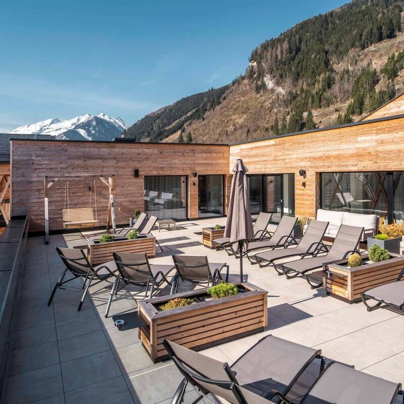 Sonnige Dachterrasse mit Liegestühlen und Bergblick