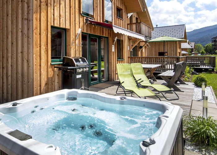 Entspannen Sie im Jacuzzi der Kreischberg Chalets an einem sonnigen Sommertag auf der Terrasse.
