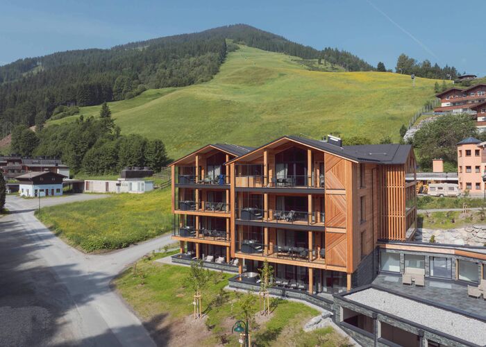 Gesamtansicht der Saalbach Suites in Saalbach-Hinterglemm im Sommer vor der alpinen Berglandschaft