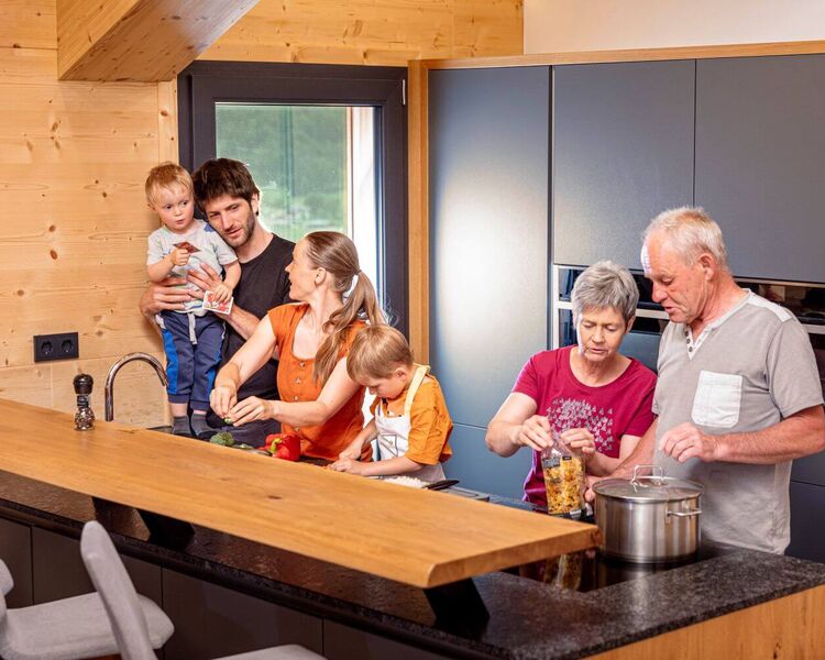 Familie mit Kleinkindern und Großeltern beim Kochen in der Ferienwohnung